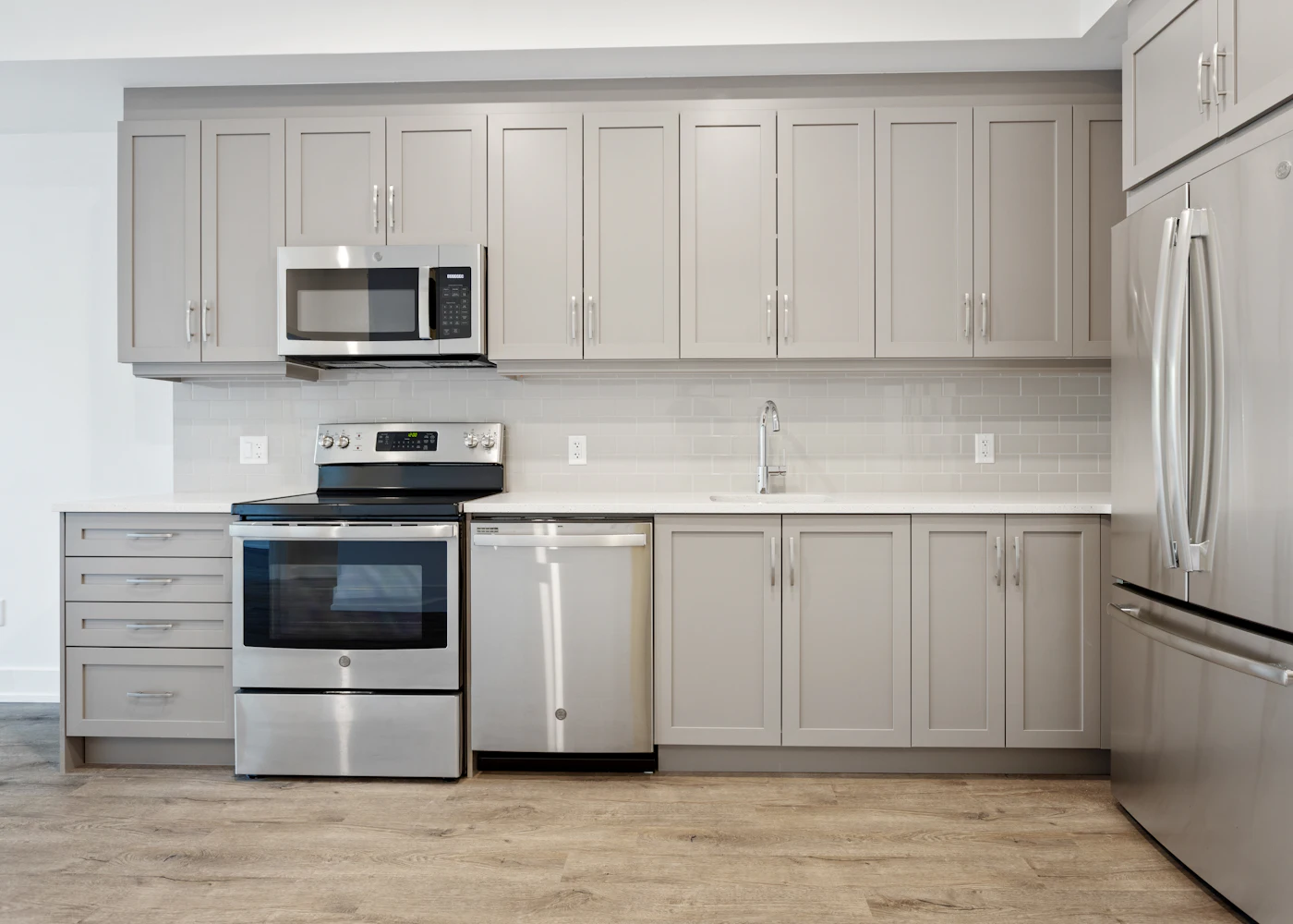 Modern kitchen with stainless steel range, microwave, dishwasher and refrigerator